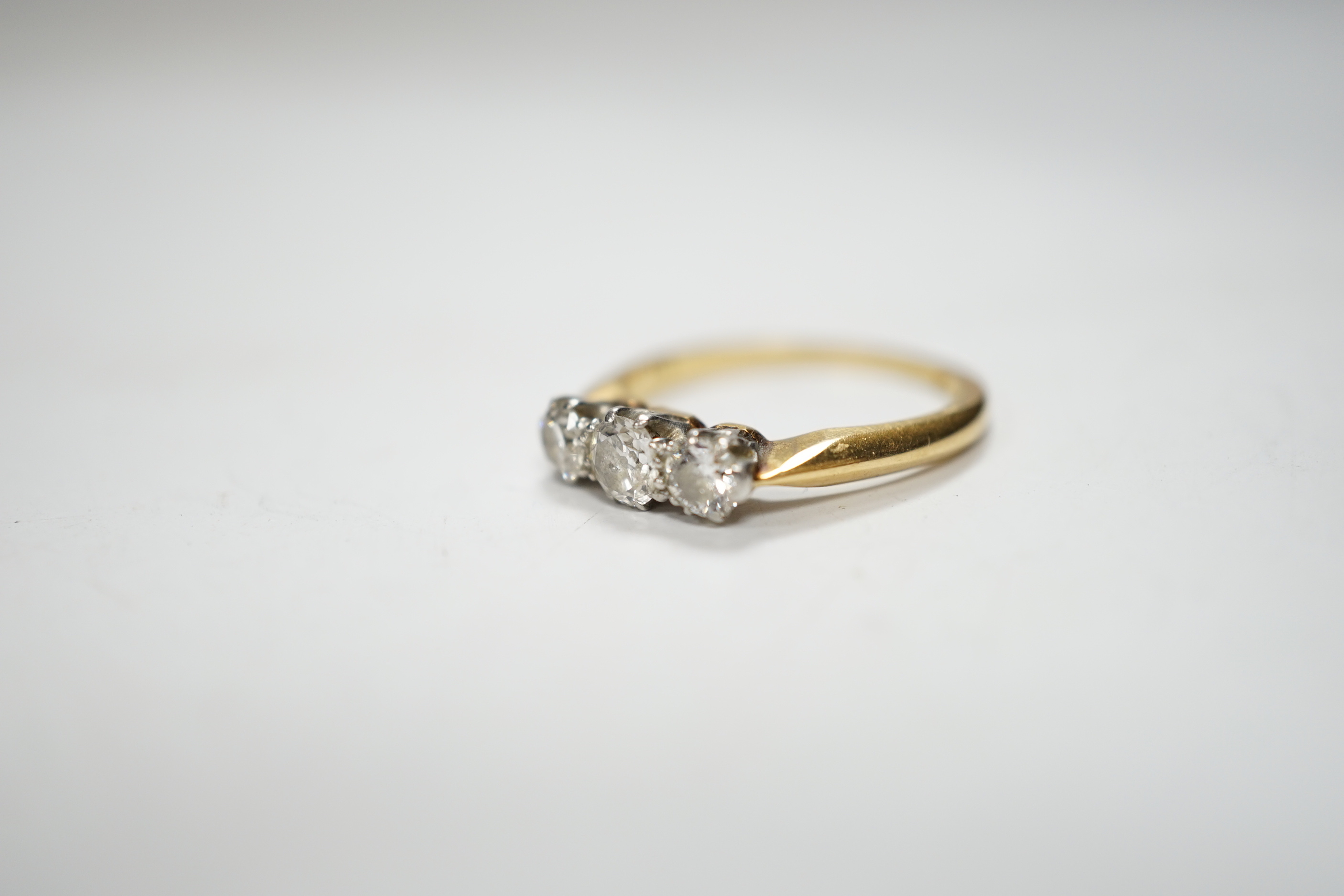An 18ctct & plat, three stone diamond set ring, size L, gross weight 3.1 grams.